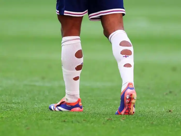 Why do pro footballers cut their socks?